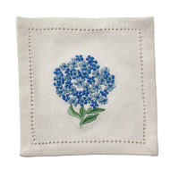 Embroidered blue flower on a beige fabric square