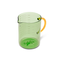 Green measuring cup with yellow handle on a white background