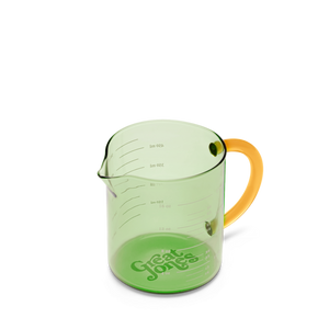 Green measuring cup with orange handle on a white background