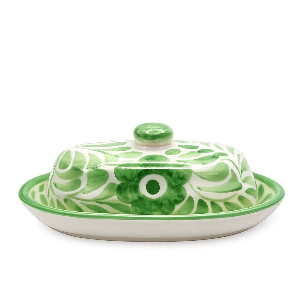 Green and white ceramic butter dish with lid on a white background