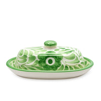 Green and white ceramic butter dish with lid on a white background