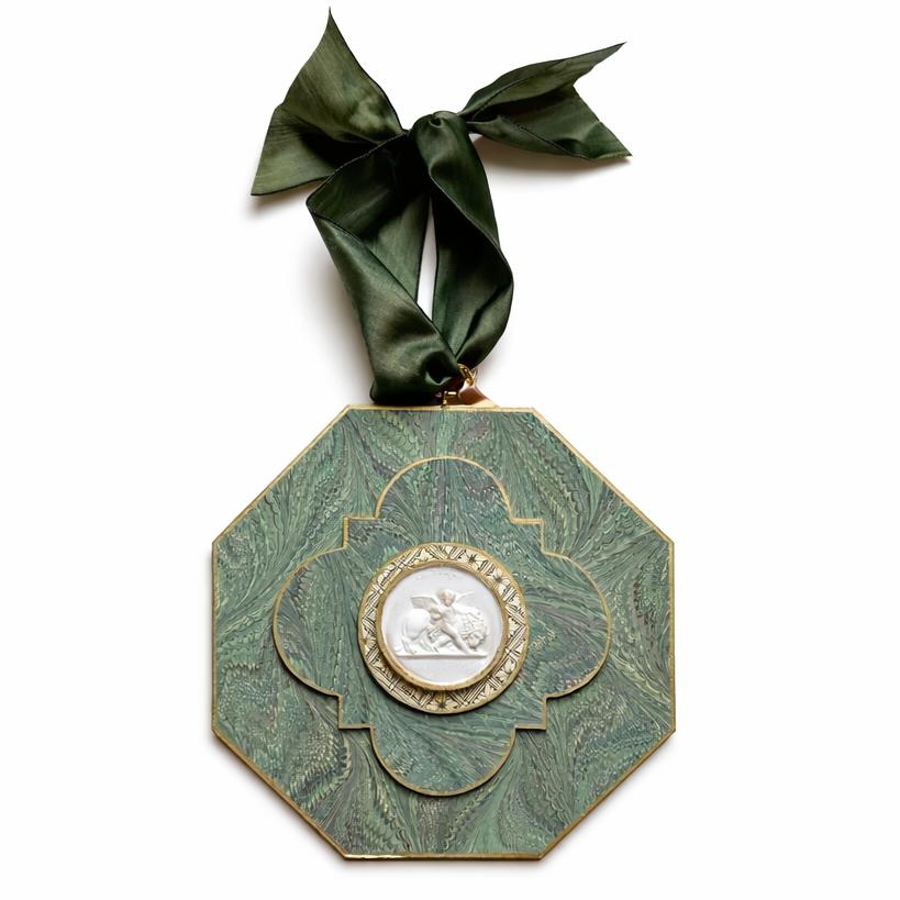 Decorative green medallion with a ribbon on a white background