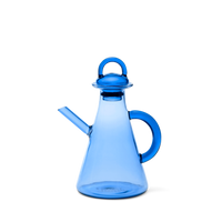 Blue glass oil bottle with a handle on a white background