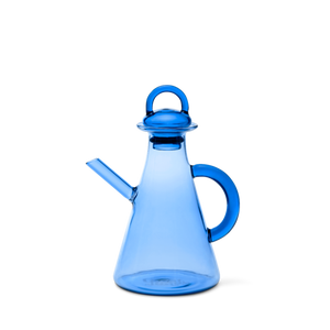 Blue glass oil bottle with a handle on a white background