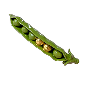 A ceramic decorative object resembling a pod of peas with gold accents, handcrafted by Minnie-Mae Stott.
