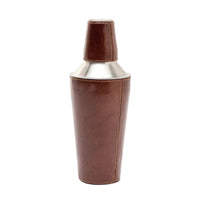 A brown tobacco-colored leather cocktail shaker with a metal shaker top and a strap closure.